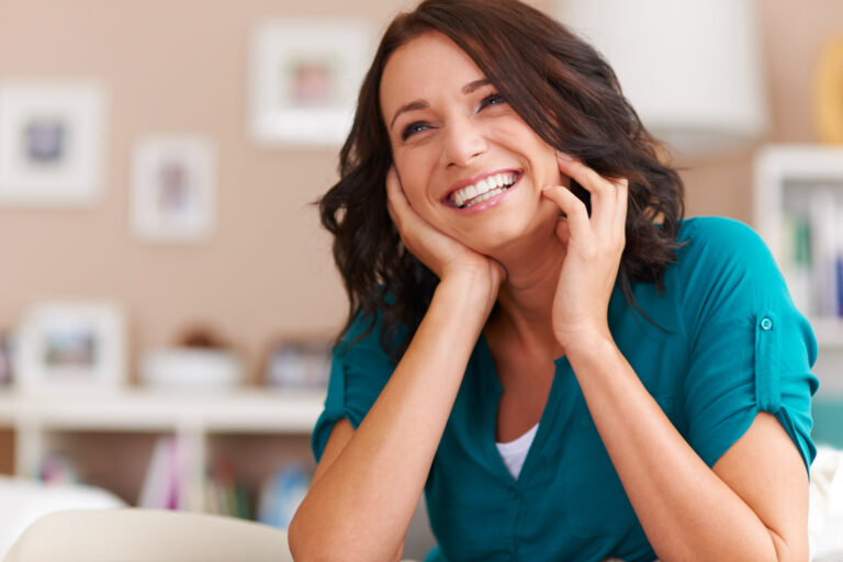 a woman smiling and showing off new dental veneers